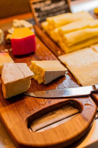 a cutting board with different types of cheese and a knife at Carmel Taíba Exclusive Resort in Taíba