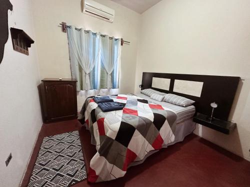 a bedroom with a bed with a checkered blanket at Sunset Hostel - Centro - in La Paz