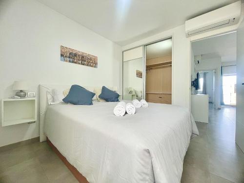 a bedroom with a white bed with towels on it at Bright Place Bungalow in San Bartolomé