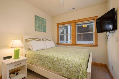 Un dormitorio con una cama y un televisor de pantalla plana. en LSC209 La Dolce Vita II, en Nags Head