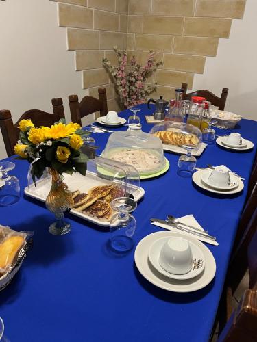 un tavolo blu con piatti di cibo e fiori sopra di Grace's House Bed and Breakfast a Gallipoli