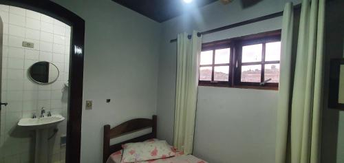 a bathroom with a sink and a toilet and a window at Casa Blanca Pousada Hotel in São Lourenço