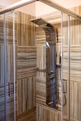 a sauna with wood paneling and a shower stall at Paradise Apartments Artemida in Artemida