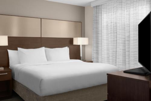 a bedroom with a large white bed and a television at Residence Inn by Marriott Santa Clarita Valencia in Santa Clarita