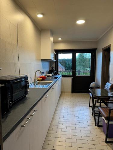 a kitchen with a sink and a table in it at Welkomhoeve in Grobbendonk