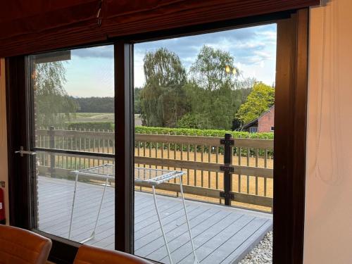 a sliding glass door with a view of a porch at Welkomhoeve in Grobbendonk