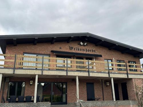 a brick building with a balcony on top of it at Welkomhoeve in Grobbendonk