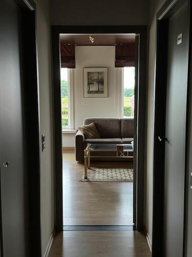 a doorway to a living room with a couch at Welkomhoeve in Grobbendonk
