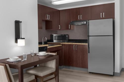 a kitchen with a white refrigerator and a wooden table at Residence Inn by Marriott Santa Clarita Valencia in Santa Clarita