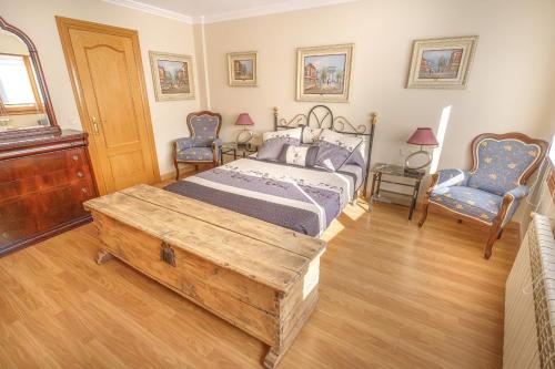 a bedroom with a bed with a wooden table and two chairs at La cabaña del cañón in Vadillo