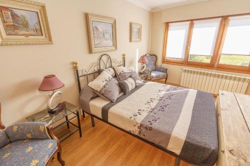 a bedroom with a large bed and a chair at La cabaña del cañón in Vadillo