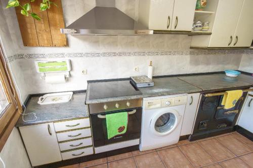a small kitchen with a washing machine in it at La cabaña del cañón in Vadillo