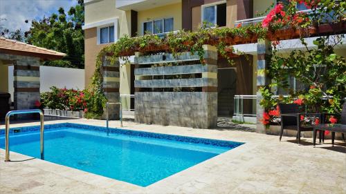 a swimming pool in front of a house at La Yarolina in Punta Cana