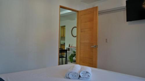 two towels sitting on a bed in front of a mirror at La Yarolina in Punta Cana