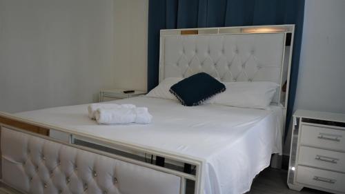 a large white bed with a blue pillow on it at La Yarolina in Punta Cana