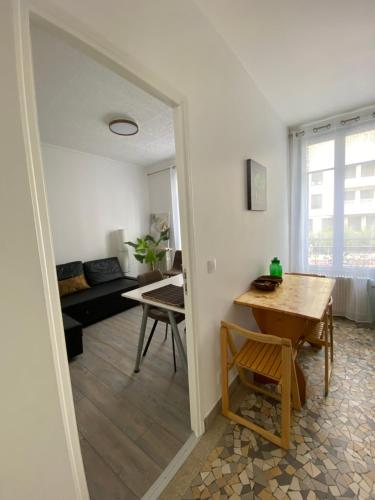 un salon avec une table et un canapé dans l'établissement Appartement de charme climatisé à Bagneux, à Bagneux