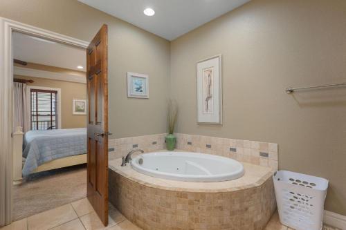 a bathroom with a bath tub with a bed at CSC3E Afternoon Delight in Kill Devil Hills