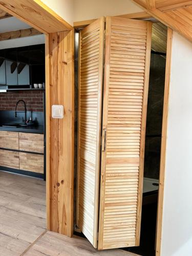 a room with a wooden door in a kitchen at Apartamenty Bezrzecze in Szczecin