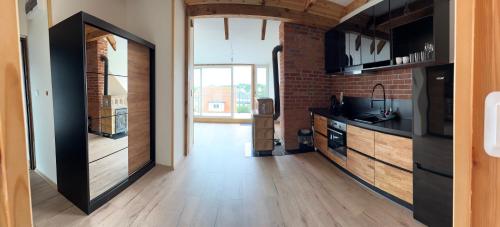 a hallway with a kitchen with a brick wall at Apartamenty Bezrzecze in Szczecin