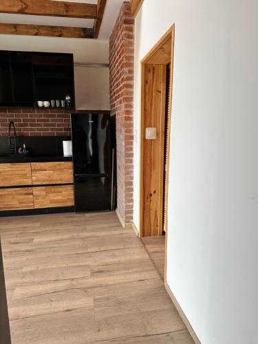 a room with a brick wall and a kitchen at Apartamenty Bezrzecze in Szczecin