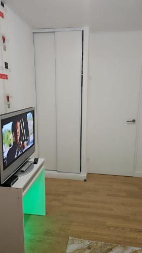 une télévision posée sur une table dans une pièce avec une porte dans l'établissement Chambre d hôte, à Bry-sur-Marne