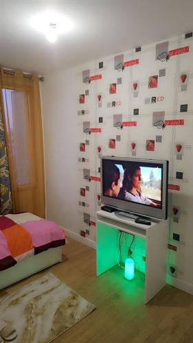 une chambre avec une télé et un mur avec des coeurs dans l'établissement Chambre d hôte, à Bry-sur-Marne