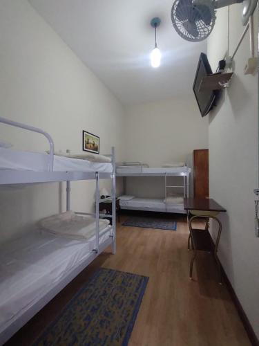 a room with two bunk beds and a desk at Hotel Cervantes in Curitiba
