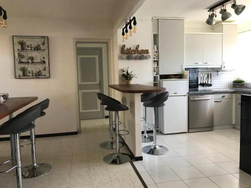 - une cuisine avec un comptoir et des tabourets de bar dans l'établissement A 15mn des plages, beau duplex à Perpignan, à Perpignan