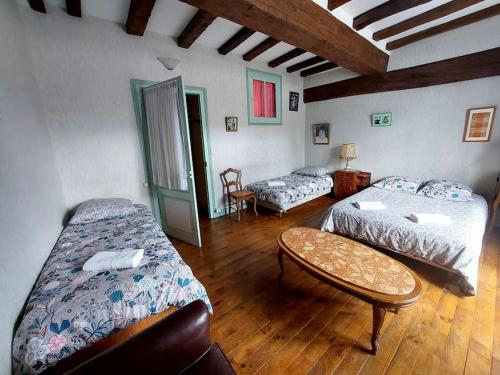 une chambre avec deux lits et une table dans l'établissement Chez Koryne, à Loudun
