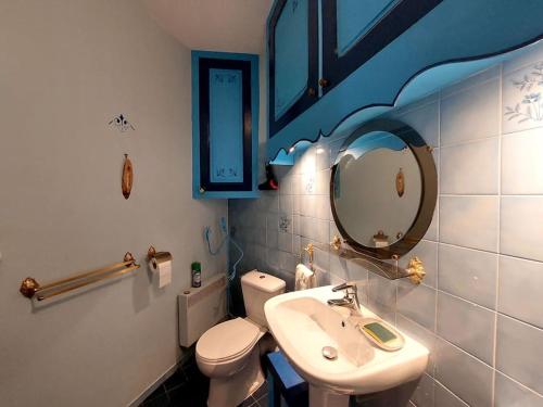 une salle de bain avec un lavabo, des toilettes et un miroir dans l'établissement Chez Koryne, à Loudun