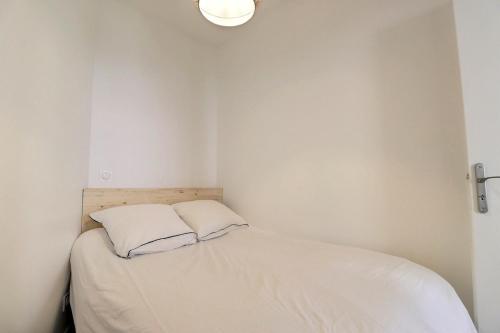 - une petite chambre avec un lit blanc et 2 oreillers dans l'établissement Le Charpennes - Beautiful T1 Apartment - Villeurbanne, à Villeurbanne