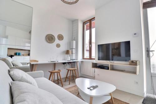 un salon blanc avec un canapé et une table dans l'établissement Le Charpennes - Beautiful T1 Apartment - Villeurbanne, à Villeurbanne
