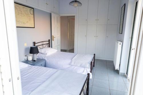 two beds in a bedroom with white walls at Salamina Blue Horizon House in Eantio