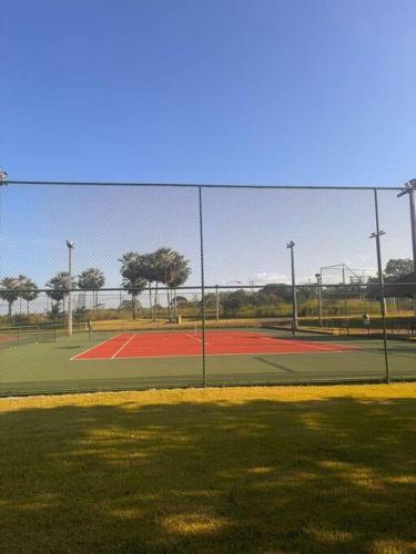 a tennis court with a fence in front of it at Apart Resort Catu Lake Catu Like in Aquiraz
