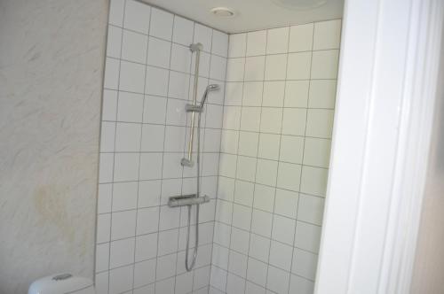 a bathroom with a shower with white tiles at långstorp höör huvudbyggnad v flygel in Höör