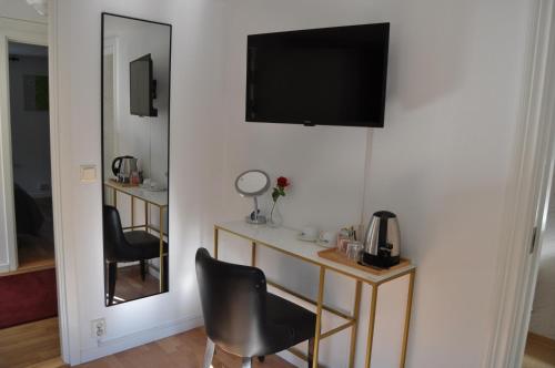 a room with a mirror and a television on a wall at långstorp höör huvudbyggnad v flygel in Höör