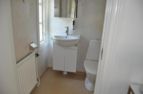a white bathroom with a sink and a toilet at långstorp höör huvudbyggnad v flygel in Höör