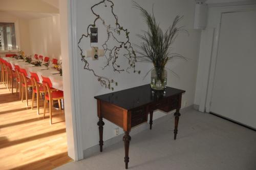 a room with a table with a vase on it at långstorp höör huvudbyggnad v flygel in Höör