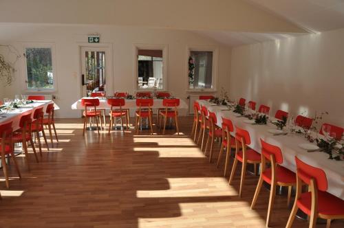 a room with tables and chairs and red chairs at långstorp höör huvudbyggnad v flygel in Höör