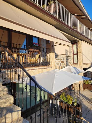 two white umbrellas on a balcony of a building at La Mira de Gredos in Hoyos del Espino