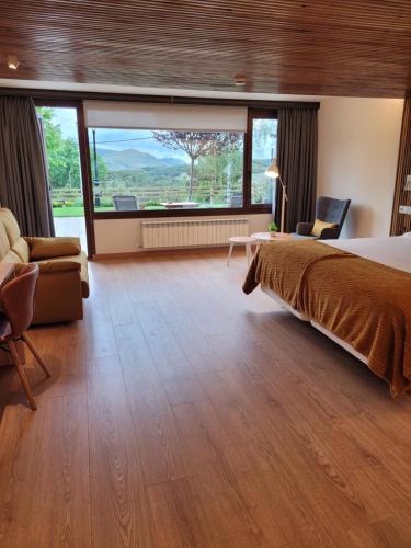a hotel room with a bed and a large window at La Mira de Gredos in Hoyos del Espino