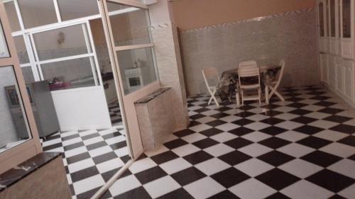 a room with a checkered floor and a table and chairs at Appartement de vacances 2 chambres à Saidia 2 min de la plage à pied in Saidia 