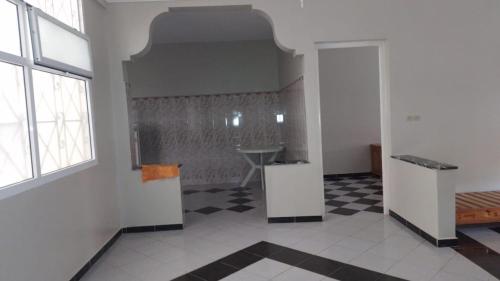 a white room with a black and white checkered floor at Appartement de vacances 2 chambres à Saidia 2 min de la plage à pied in Saidia 