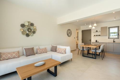 a living room with a white couch and a table at Villa Erato - Elysian Villas Kefalonia, 200m from Beach, New 2024 in Minia