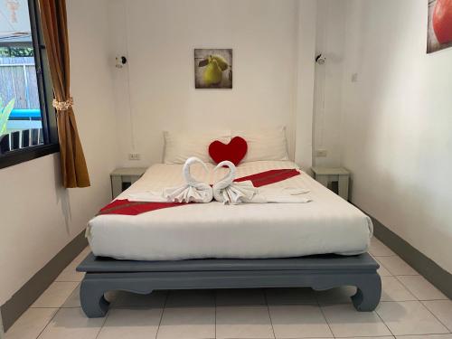 a bedroom with a bed with a heart on it at Deng's Budget Room in Kamala Beach