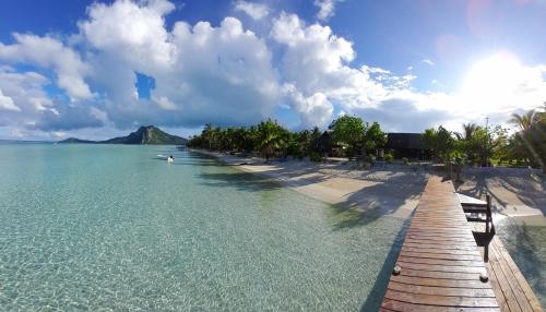 a beach with a wooden pathway and the ocean at Fare ATAROA in Te-Fare-Arii