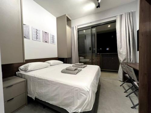 um quarto com uma cama branca com toalhas em Studio Especial Moema pra você! em São Paulo