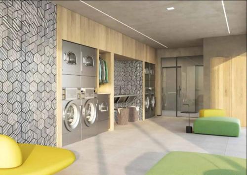 uma lavanderia com máquinas de lavar e um pufe amarelo em Studio Especial Moema pra você! em São Paulo