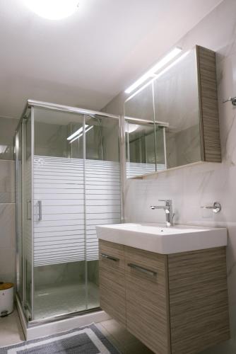 a bathroom with a sink and a shower at Kampos Bliss Apartments in Votsalákia