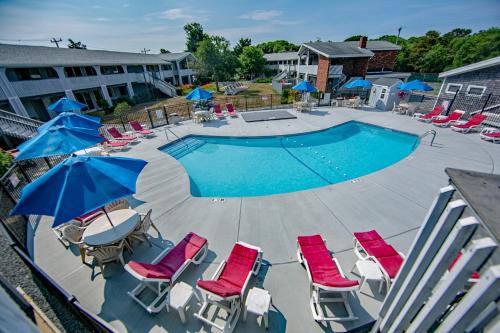 a swimming pool with chairs and umbrellas next to a pool at Eastwood at Provincetown in Provincetown